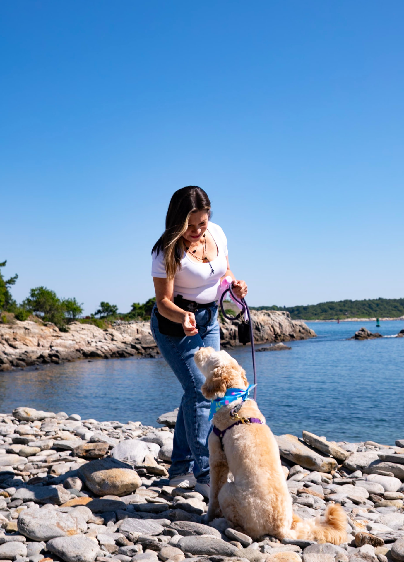 Edelys spending time with a happy dog on the Maine coast